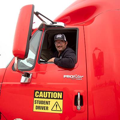 Man smiling out of window of semi truck