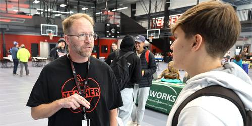 Instructor speaking with student at career day