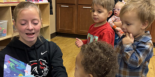 Student reading to children