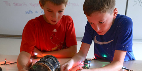 Two boys looking down at a small treasure chest