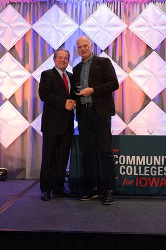Two men posing with award