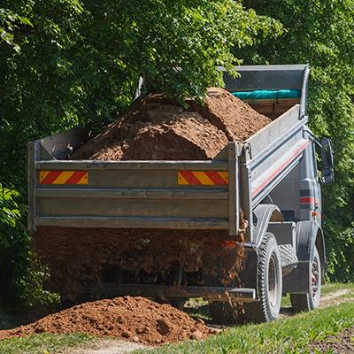 Dump truck dropping dirt on ground